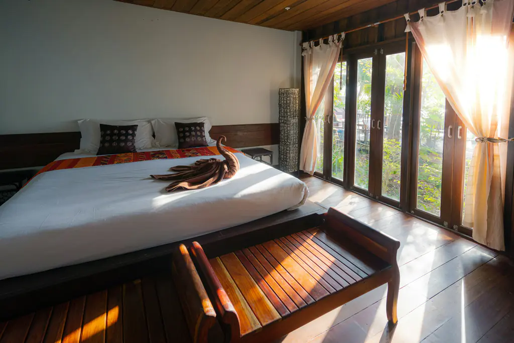 Ocean View Villa bedroom with a white king bed and sunlit floor-to-ceiling glass doors