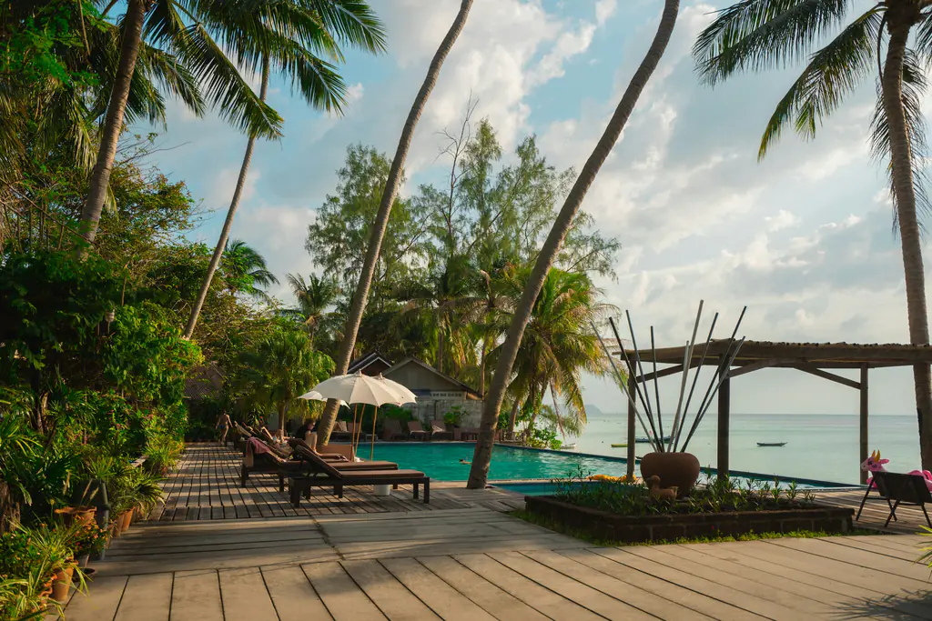 A teak sun deck and pavilion at the edge of the beach, facing the sea